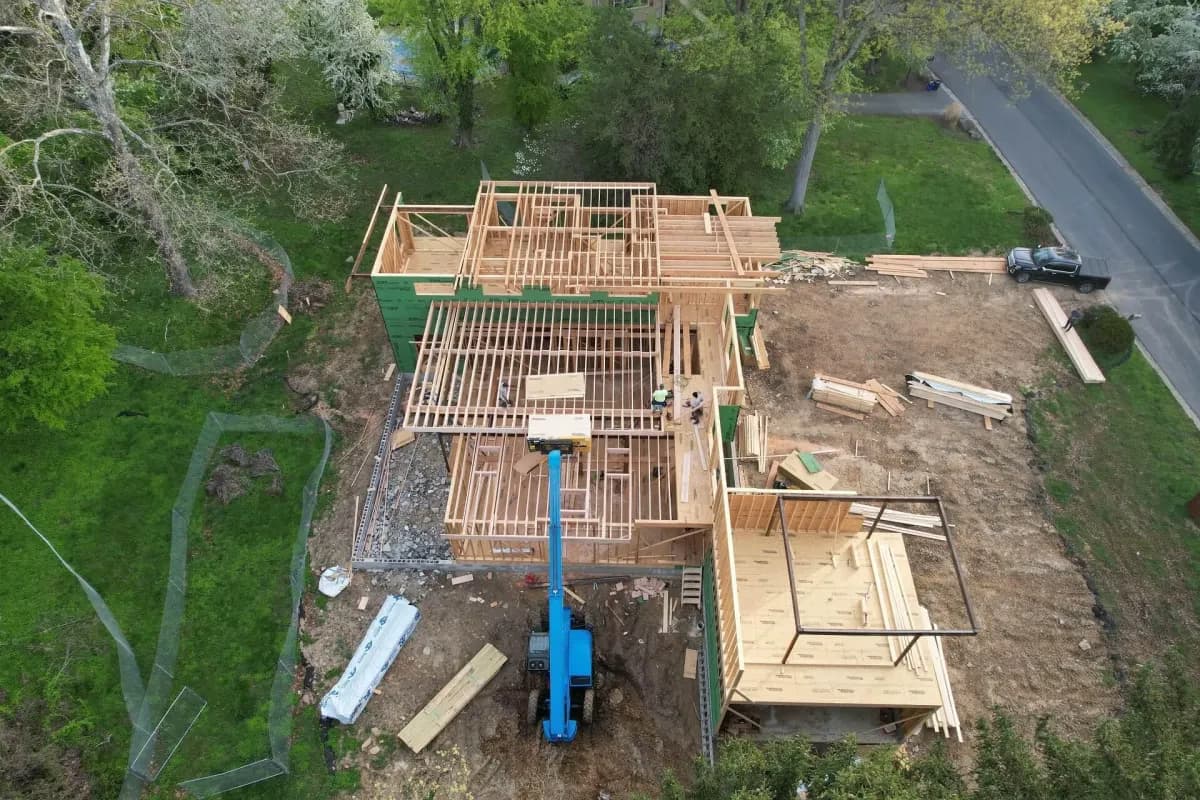 Aerial drone view of wood framing with blue telehandler — Treacy Brothers ground-up construction